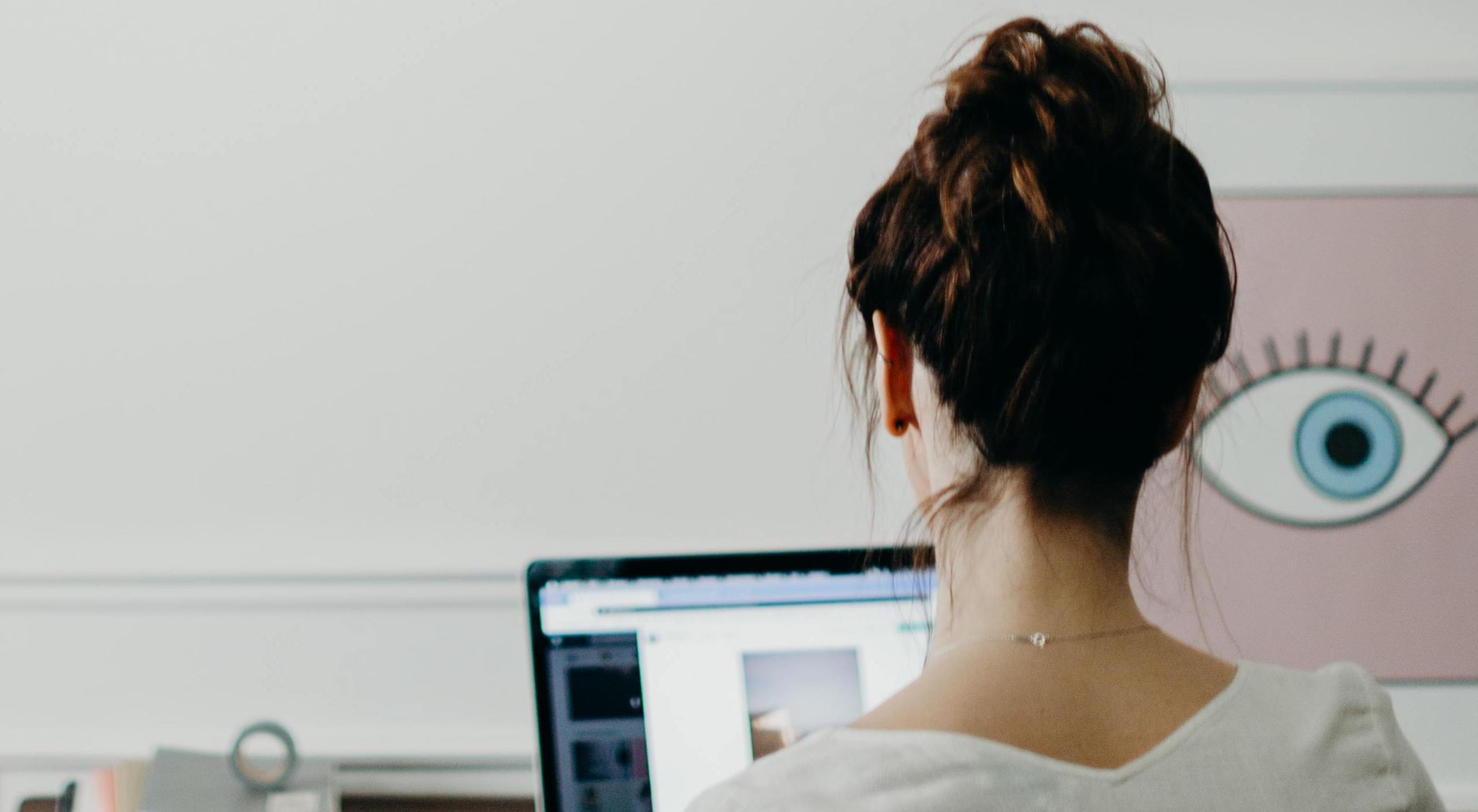 Junge Frau schaut auf Laptop